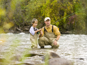 A Father teaching his son to fly fish in a bubbling river. Father's Day Gift Guide, Trueheartgal.